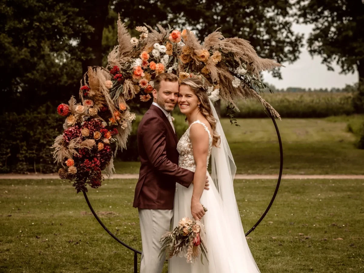 bruidspaar bij bloemen backdrop bruiloft