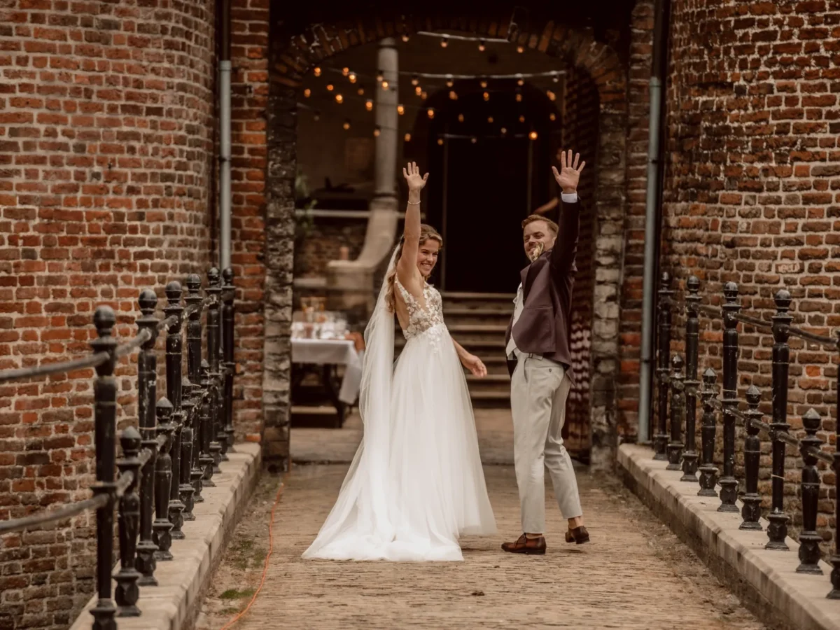 Kasteel Dussen - Bruidspaar trouwt bij Kasteel Dussen en zwaait naar de gasten op de brug na de ceremonie.