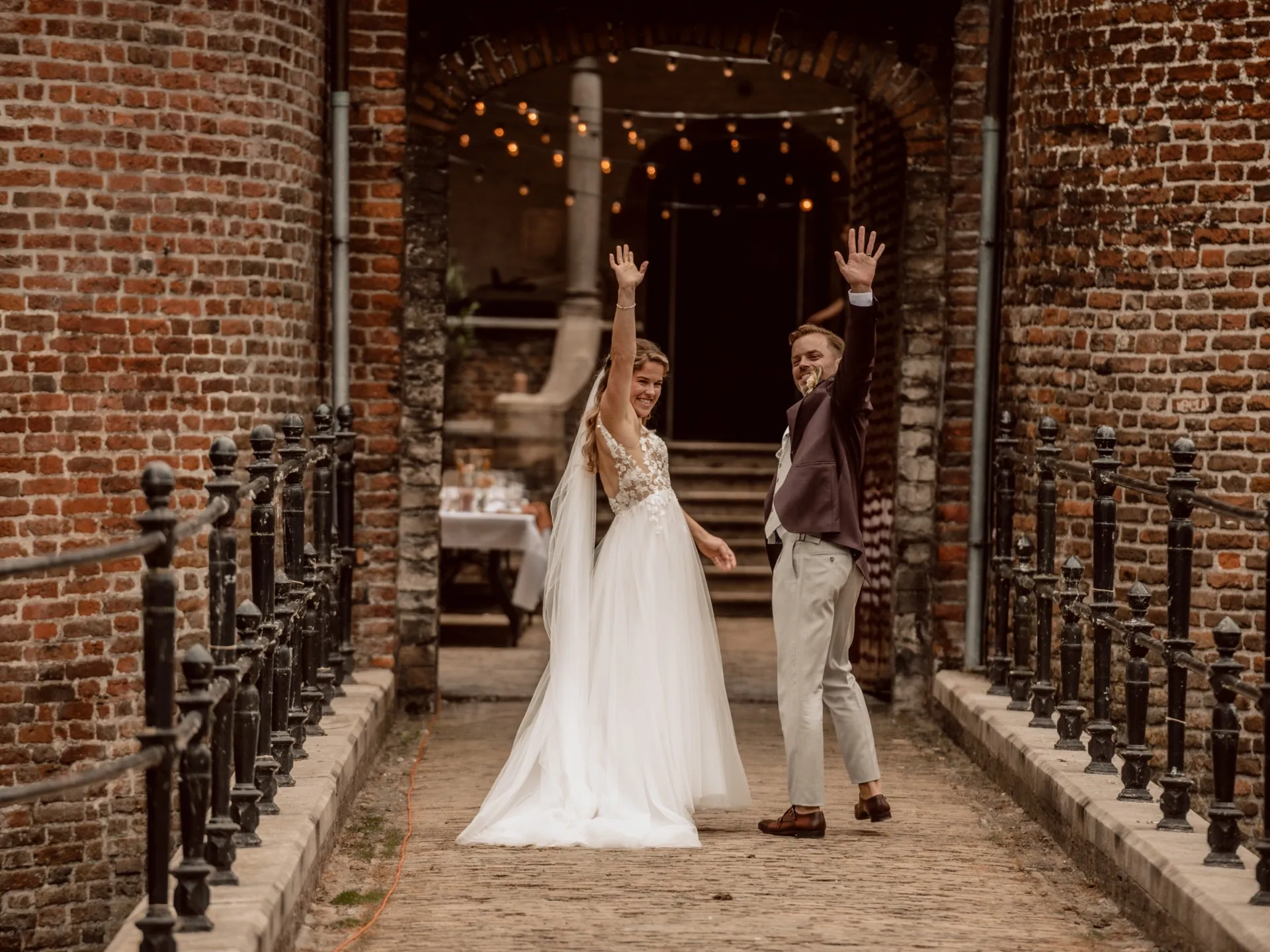 Kasteel Dussen - Bruidspaar trouwt bij Kasteel Dussen en zwaait naar de gasten op de brug na de ceremonie.