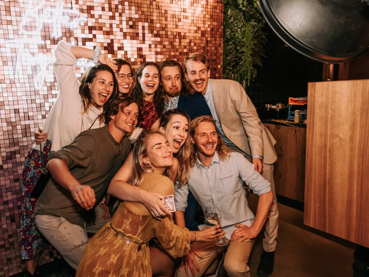 bruiloftsgasten maken plezier in de photobooth bij Het Houtse Meer